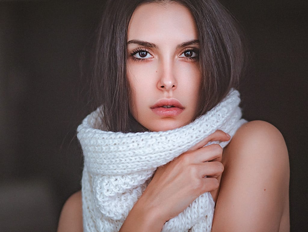 Close up of woman's face that is wearing a big scarf around her neck